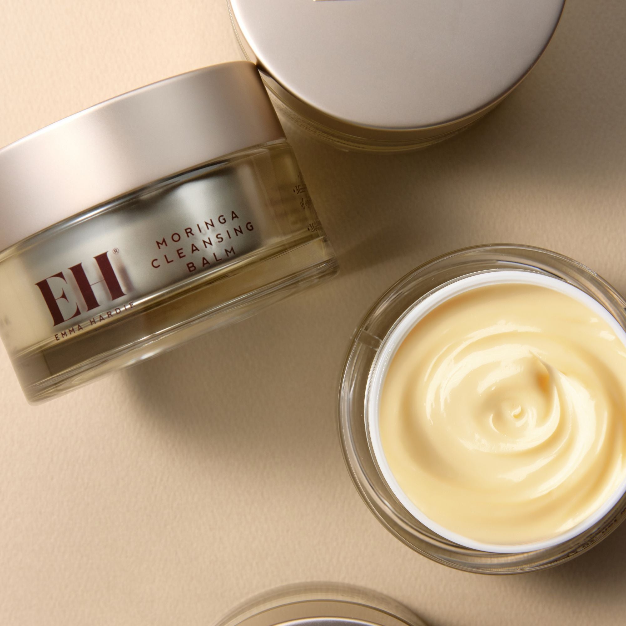 Emma Hardie Moringa Cleansing Balm jar with balm inside on a beige background