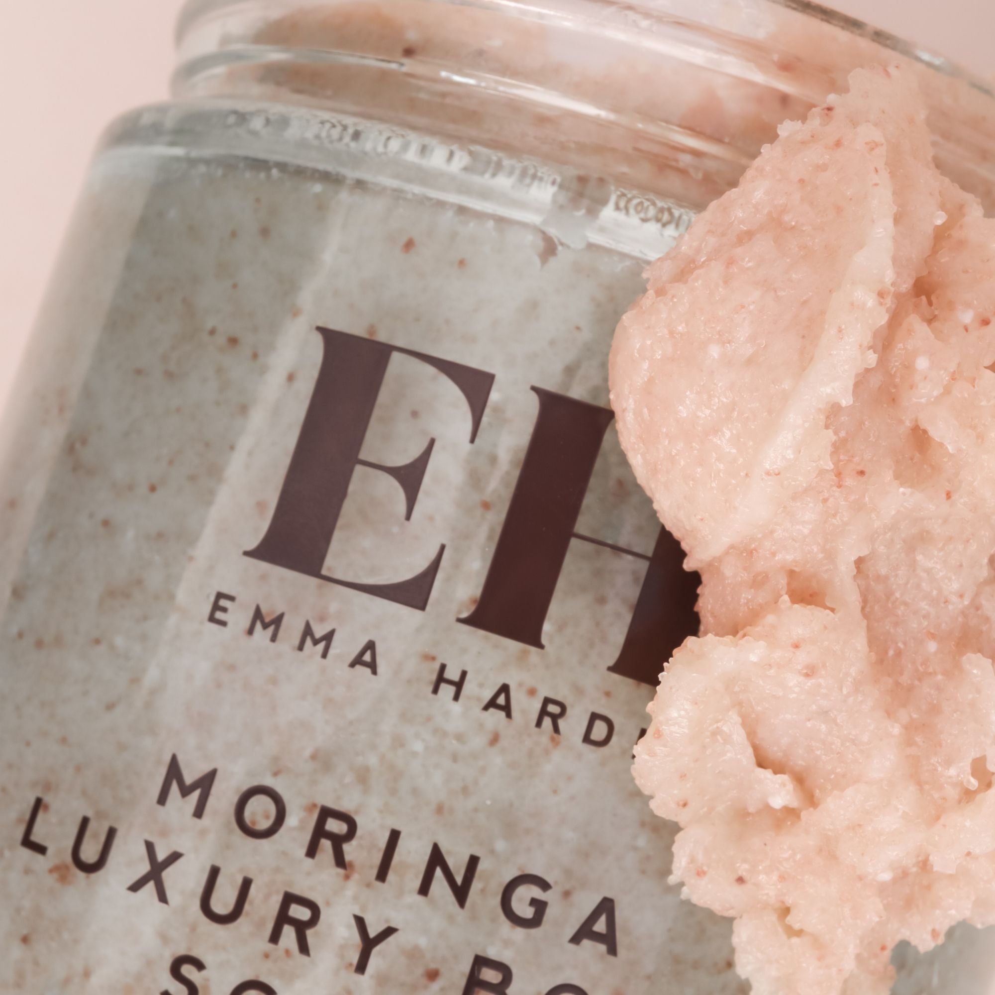 Close-up of Emma Hardie Moringa Luxury Body Scrub jar with the exfoliating scrub texture shown beside the packaging.