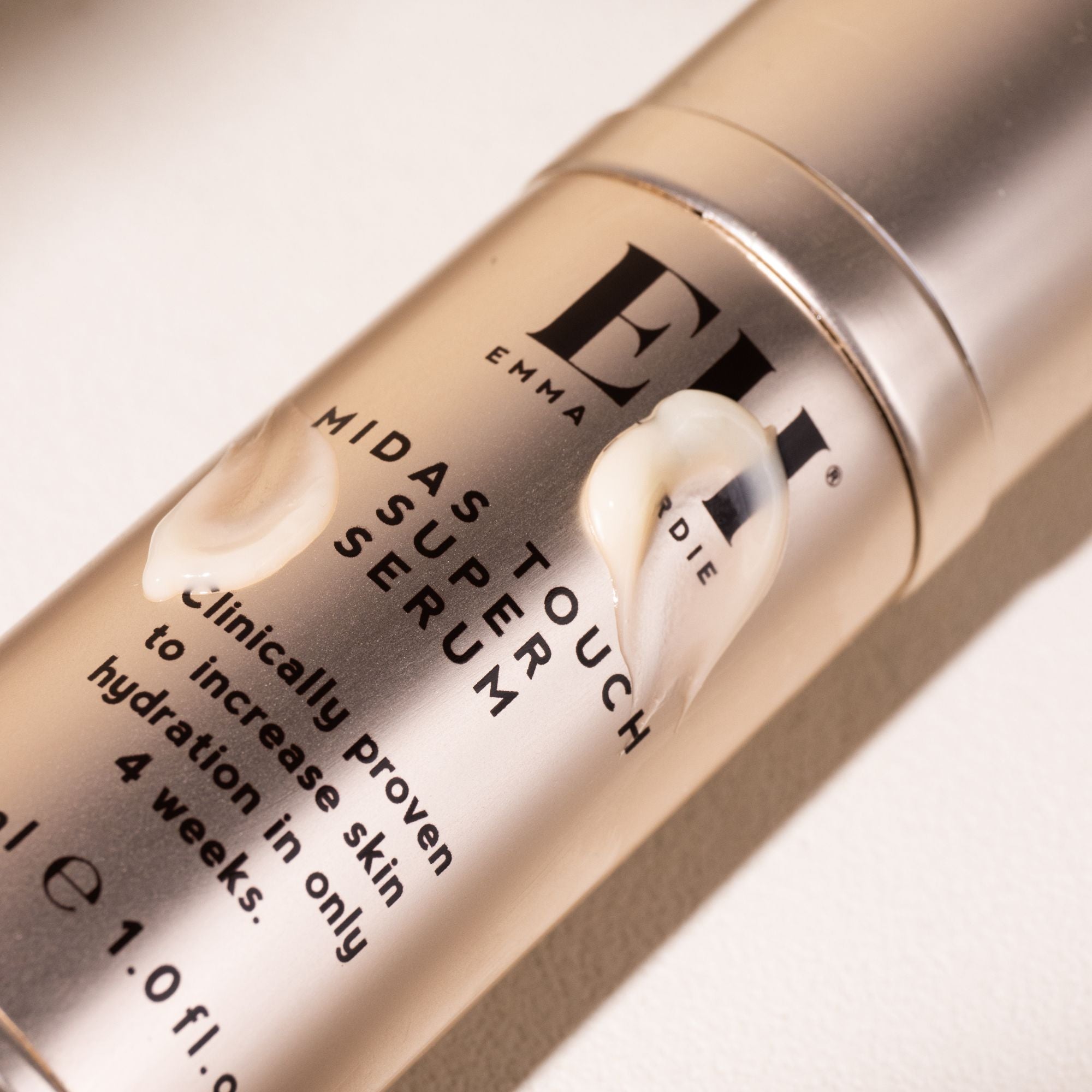 Close-up of Emma Hardie Midas Super Serum bottle on a light background