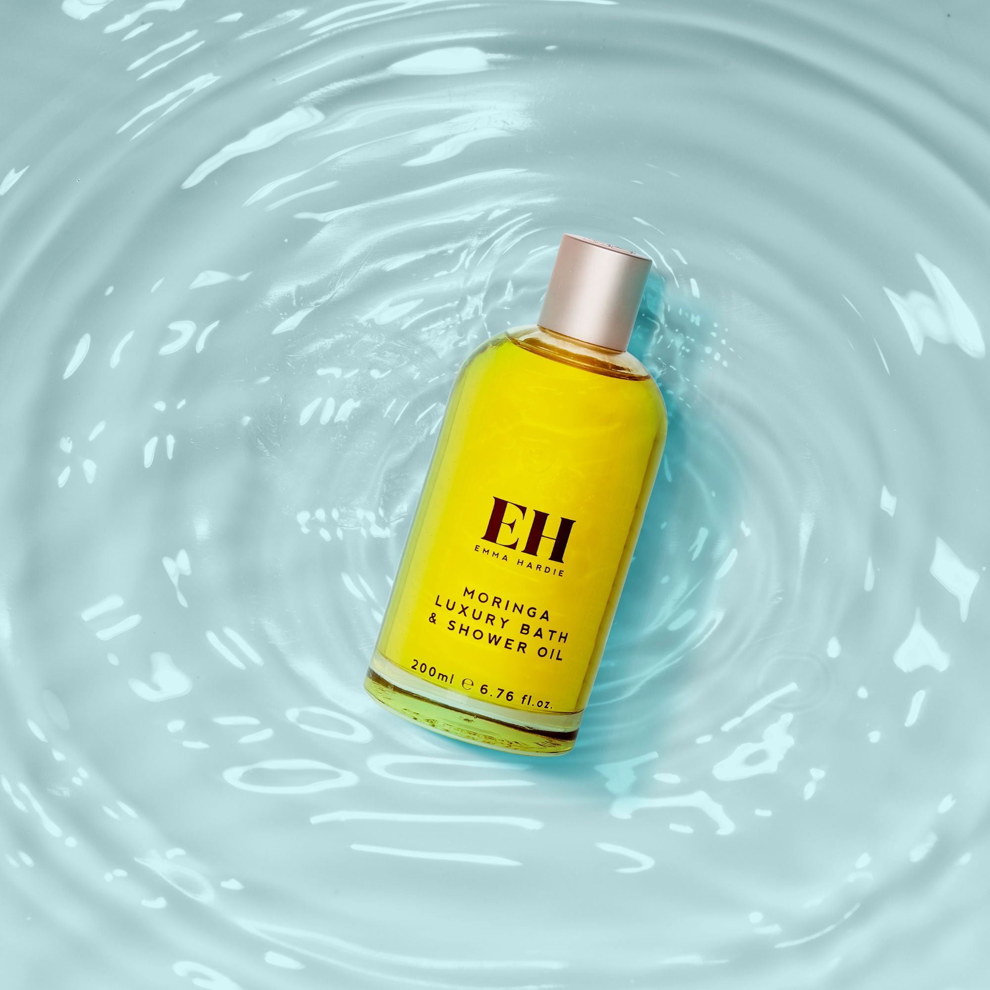 Yellow bottle of EH Luxury Bath & Shower Oil on water surface