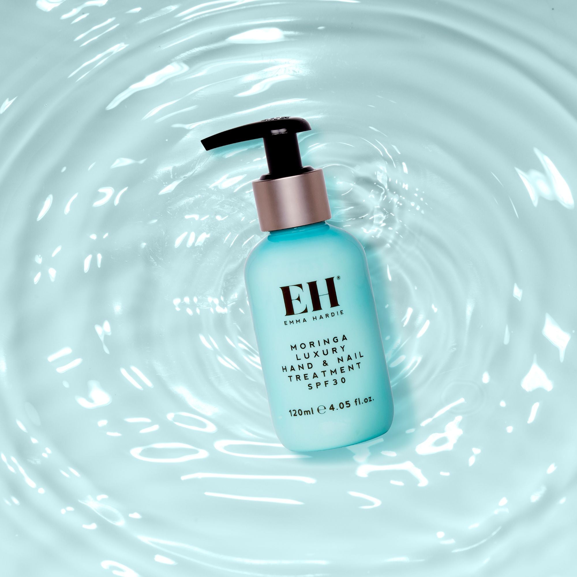 Emma Hardie Moringa Luxury Hand and Nail Treatment SPF30 bottle floating against a soft blue water ripple background.