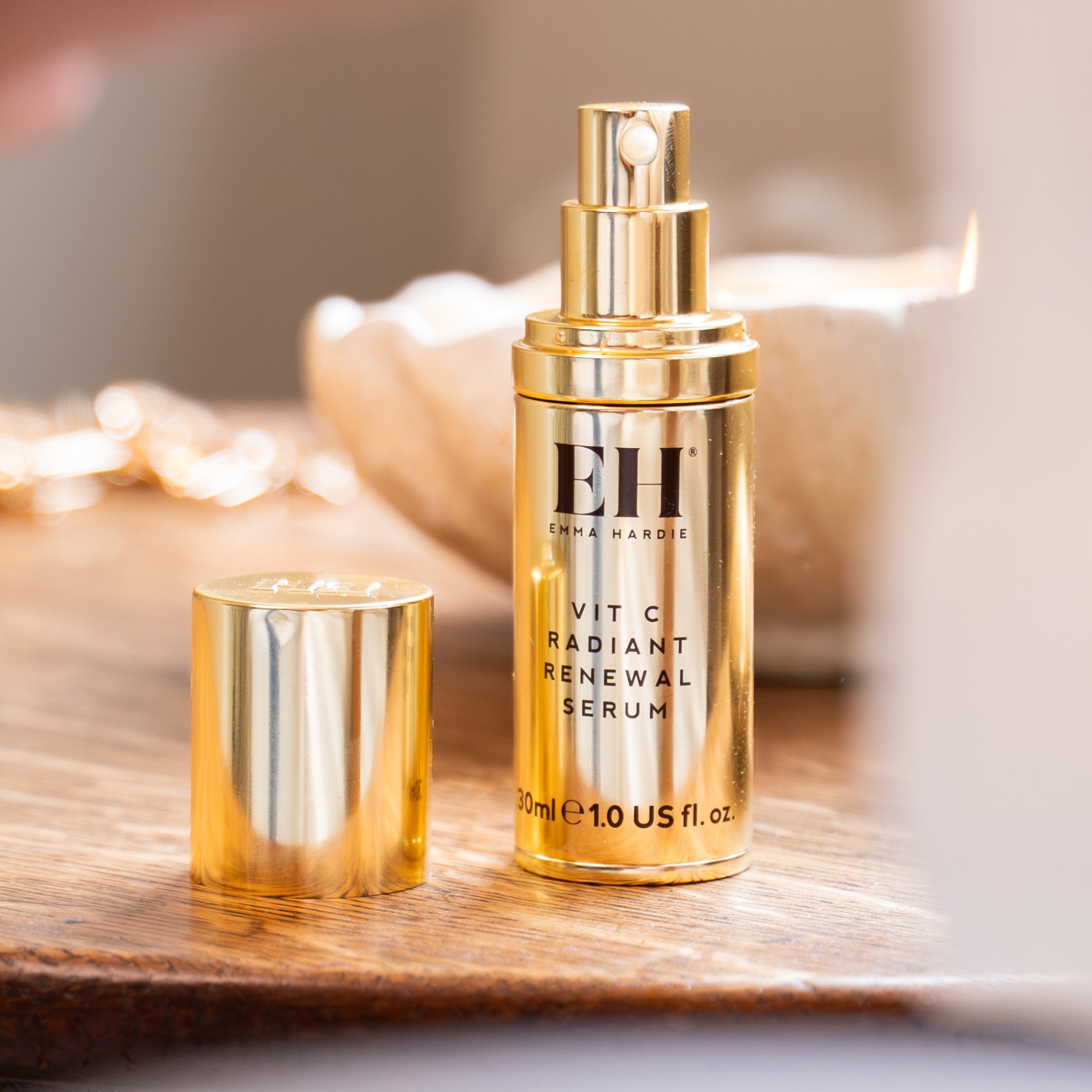 Gold Emma Hardie Vit C Radiant Renewal Serum bottle on a wooden surface.