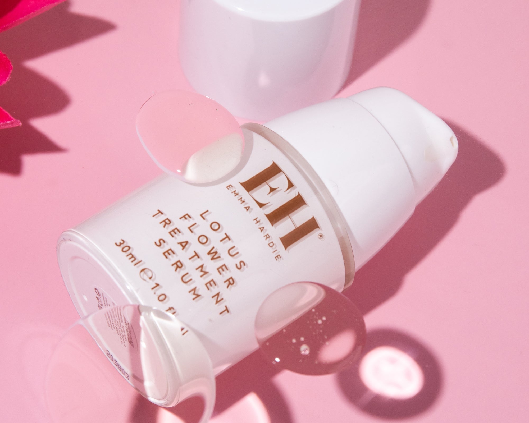 Emma Hardie Lotus Flower Treatment Serum with a drop of serum on a soft pink background.