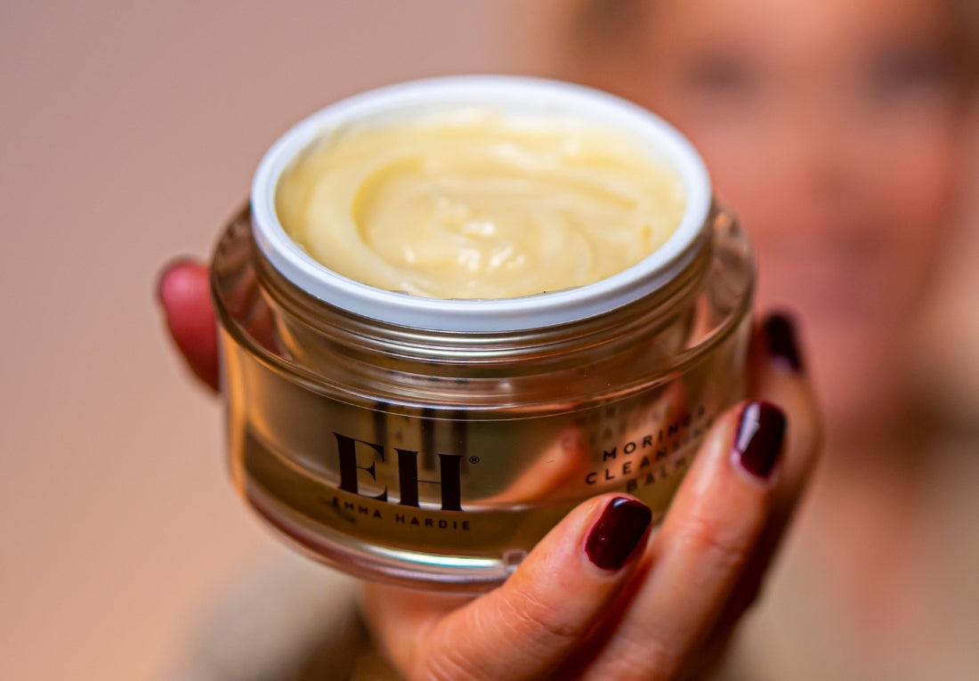 Emma Hardie Moringa Cleansing Balm open jar held in hand, showing its rich balm-to-oil cleansing texture.