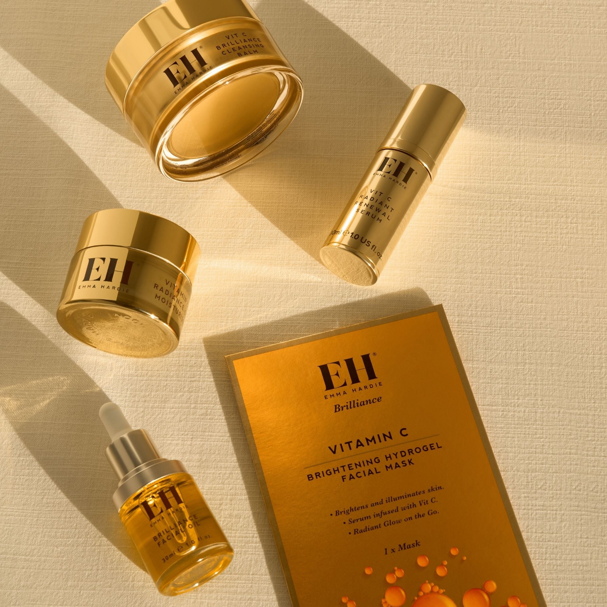 Emma Hardie Vit C Brilliance skincare collection arranged in warm sunlight, including balm, serum, moisturiser, facial oil and mask.