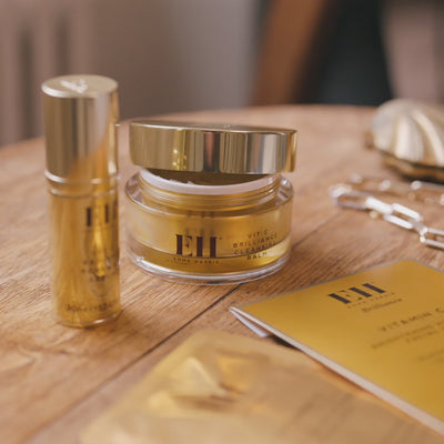 Woman opening a Vit C Brilliance Balm and breathing in the scent. 